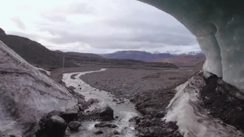 Aerial Drone view flying through Iceland Glacier cave with melting ice stream Stock Footage 240144572