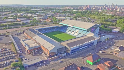 Aerial drone view flying toward Elland Road Stadium in Leeds, UK, as football Vídeo Stock 313657035