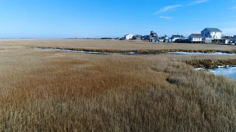 Aerial Drone view flyover grass in bay Gilgo Beach houses Видео 102534366