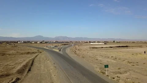 Aerial drone view of a forked road cutting through a barren desert landscape Stock Footage 307792401