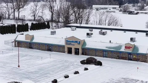 Aerial drone view of Goodwill store and empty parking lot covered in fresh Stock-Footage 331959550