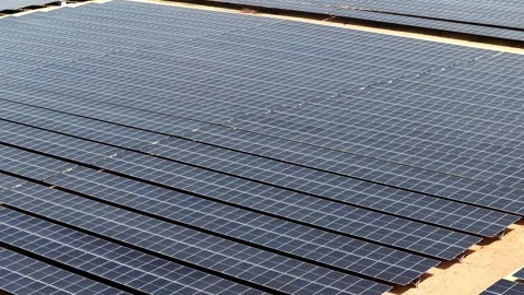 Aerial drone view of ground-mounted solar panel array in dry landscape Stock Footage 332590206