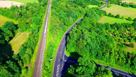 Aerial drone view of high speed passenger train traveling beside motorway Stock Footage 341195105