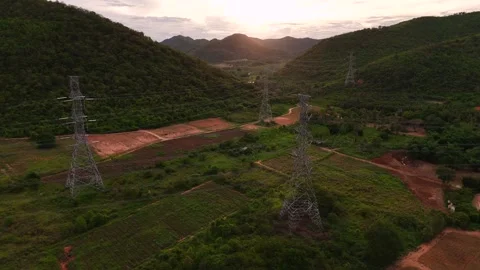Aerial drone view of high voltage power lines crossing lush farmland and Stock Footage 315225161
