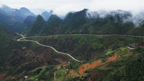Aerial Drone View of Hillside Road Cutting Across Steep Mountain Slopes in Stock Footage 332604272