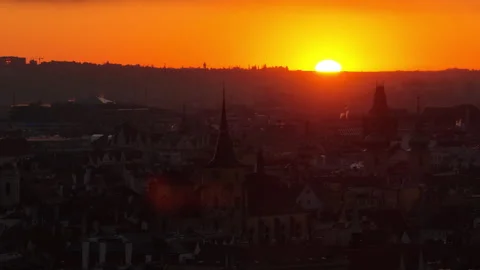 Aerial drone view of historic district church spires silhouetted against a fiery Stock Footage 336602000