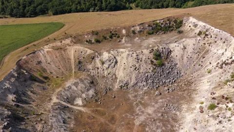 Aerial drone view of Industrial limestone quarry operating with a wind turbine Stock Footage 345500587