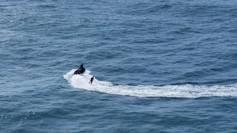 Aerial drone view of a jetski pulling a surfer in Nazare, Portugal Stock Footage 287731856