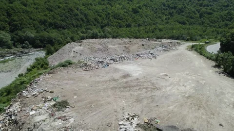 Aerial drone view of large garbage landfill close to clean mountain river. Video stock 261045103