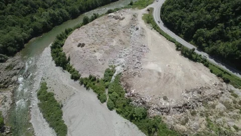 Aerial drone view of large garbage landfill close to clean mountain river. Stock Footage 261045120