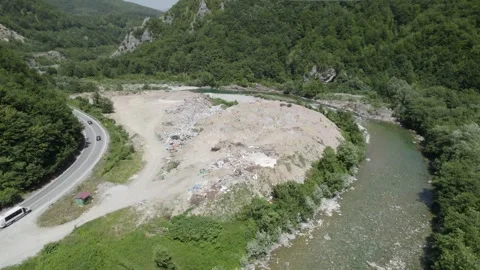 Aerial drone view of large garbage landfill close to clean mountain river. Stock Footage 261045121