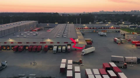 Aerial Drone View of Large Logistics Warehouse Complex at Sunset | Semi Trucks Stock Footage 328753073