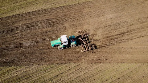 Aerial drone view of large tractor cultivates field and prepares soil for sowing Stock Footage 108547727