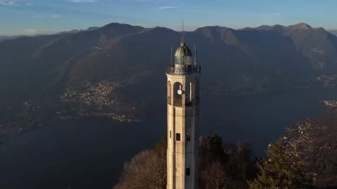 Aerial drone view of a lighthouse over Lake Como skyline with sunset light Stock Footage 169539915