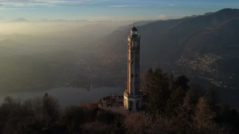 Aerial drone view of a lighthouse over Lake Como skyline with sunset light Stock Footage 169540208