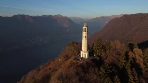 Aerial drone view of a lighthouse over Lake Como skyline with sunset light Stock Footage 169540229