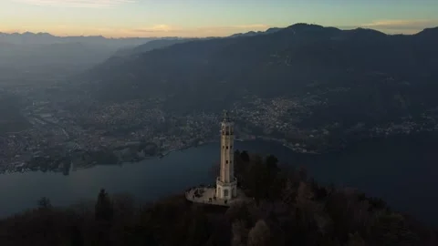 Aerial drone view of a lighthouse over Lake Como skyline with sunset light Stock Footage 170665718