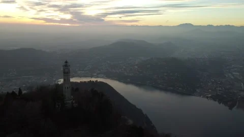 Aerial drone view of a lighthouse over Lake Como skyline with sunset light Stock Footage 170665731