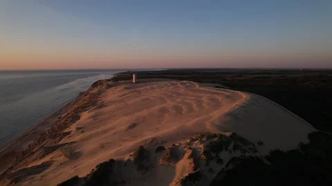 Aerial Drone View of Lighthouse on Sandy Coast at Sunset Stock Footage 343535174