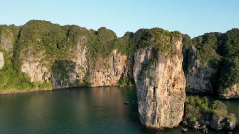 Aerial drone view of a limestone sea stack rising from calm tropical waters in 库存影片 330800480
