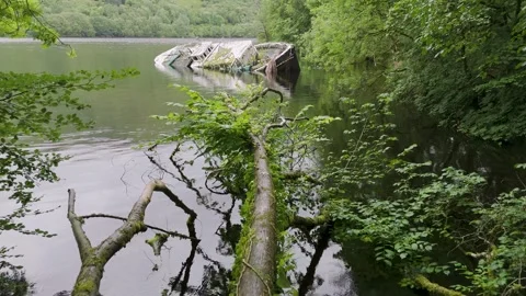 Aerial drone view of Loch Ness with an old boat resting near the shore Stock Footage 304604291