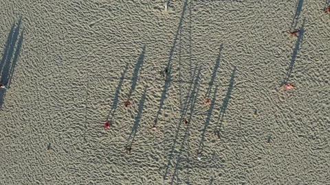 Aerial drone view of long shadows of the volleyball players at Manhattan Beach Stock Footage 317856490
