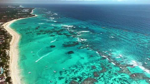 Aerial drone view of a long white beach with turquoise shallows, a reef line and Vidéo 344967456