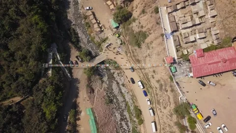Aerial drone view looking down away from a suspension bridge with people walking 库存影片 198795127