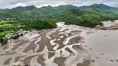 Aerial drone view of low-tide flats with winding sandbank patterns and scattered Видео 336680370