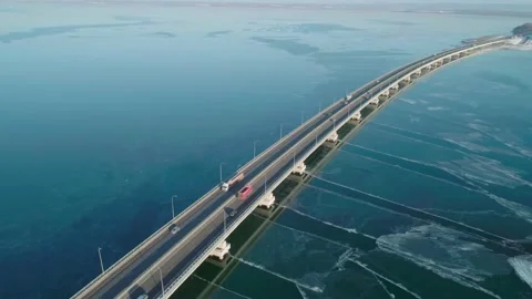 Aerial drone view of low-water bridge across the bay with moving car. Active Stock Footage 144935546