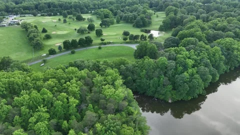 Aerial Drone View of Lush Golf Course and Lake Bordered by Dense Forest Vidéo 341989191