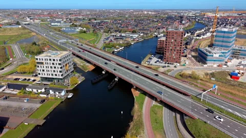 Aerial drone view of a major highway bridge crossing a canal in a modern Stock Footage 337705282