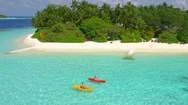 Aerial Drone View Of A Man And Woman Couple Kayaking Around A Tropical Island. Stock Footage