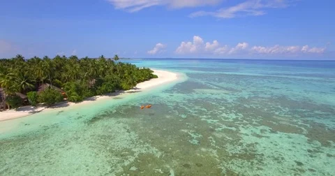 Aerial drone view of a man and woman couple kayaking around a tropical island. Stock Footage
