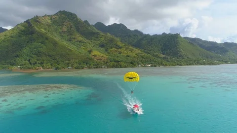 Aerial drone view of a man and woman couple parasailing tandem over a tropical i Stock Footage 110051085