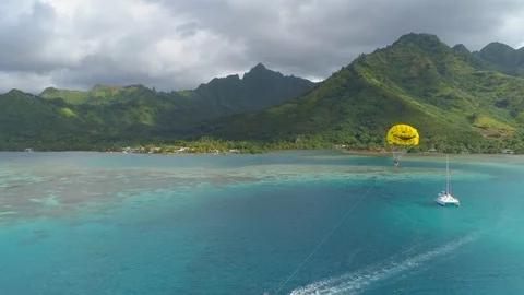 Aerial drone view of a man and woman couple parasailing tandem over a tropical i Stock Footage 110051884