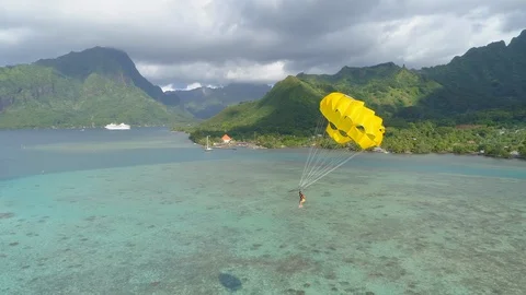 Aerial drone view of a man and woman couple parasailing tandem over a tropical i Stock Footage 110052773