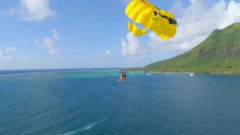Aerial drone view of a man and woman couple parasailing tandem over a tropical i Stock Footage 110056757