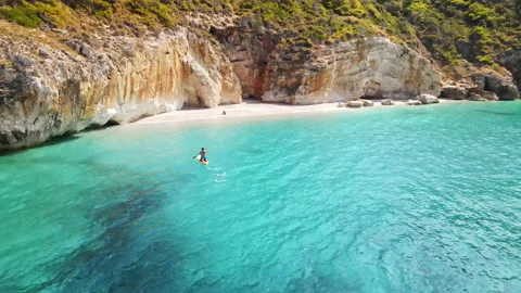 Aerial drone view of a man floating on a boat near the coast of Zakynthos, Stock Footage 165061905