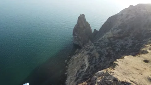 Aerial drone view of a man flying a white and blue paraglider over a hill and Stock Footage 171653019