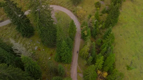 Aerial drone view of a man pushing a gravel bike uphill toward Soinsee lake Video stock 326793711