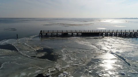Aerial drone view man waking pier icy water Long Island NY Stock Footage 102529290