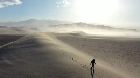 Aerial Drone View of a man walking across the top of a Sand Dune Stock Footage 326721317