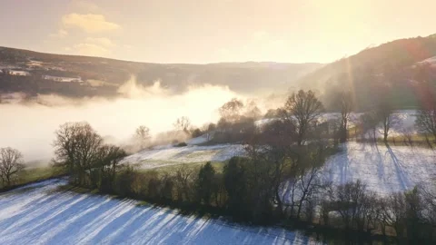 Aerial drone view of mist in a valley on a cold winters day with snow and Stock Footage 231059698