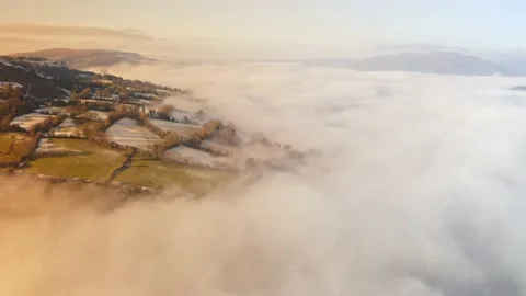 Aerial drone view of mist in a valley on a cold winters day with snow and Stock Footage 232052145