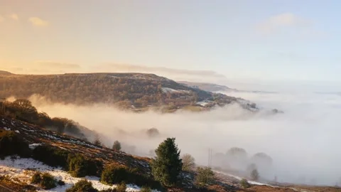 Aerial drone view of mist in a valley on a cold winters day with snow and Stock Footage 232053475