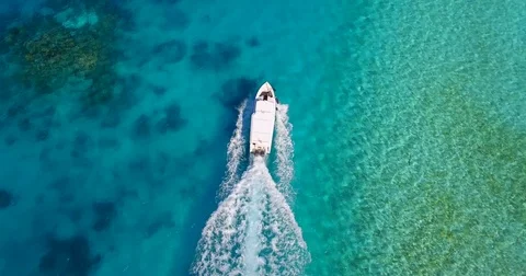 Aerial drone view of a motor boat going to a scenic tropical island in the Maldi Stock Footage