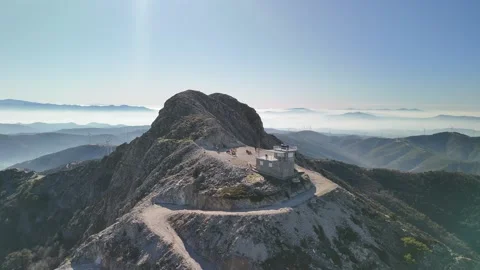 Aerial Drone View of a Mountain Summit Fire Watch Tower Surrounded by Nature Stock Footage 340104208