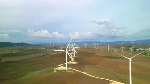 Aerial drone view moving away from wind mill turbine farm Stock Footage 293064146