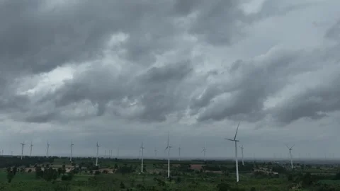 Aerial drone view of multiple wind turbines beneath dark storm clouds. Vídeo Stock 339405386